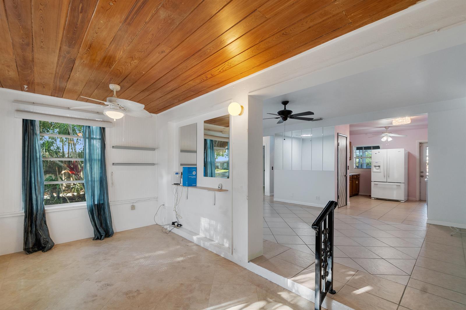 A living area with a wood-paneled ceiling leads to a tiled kitchen and dining space — 1545 Highland Avenue, Vero Beach FL 32960, VERO BEACH, FL