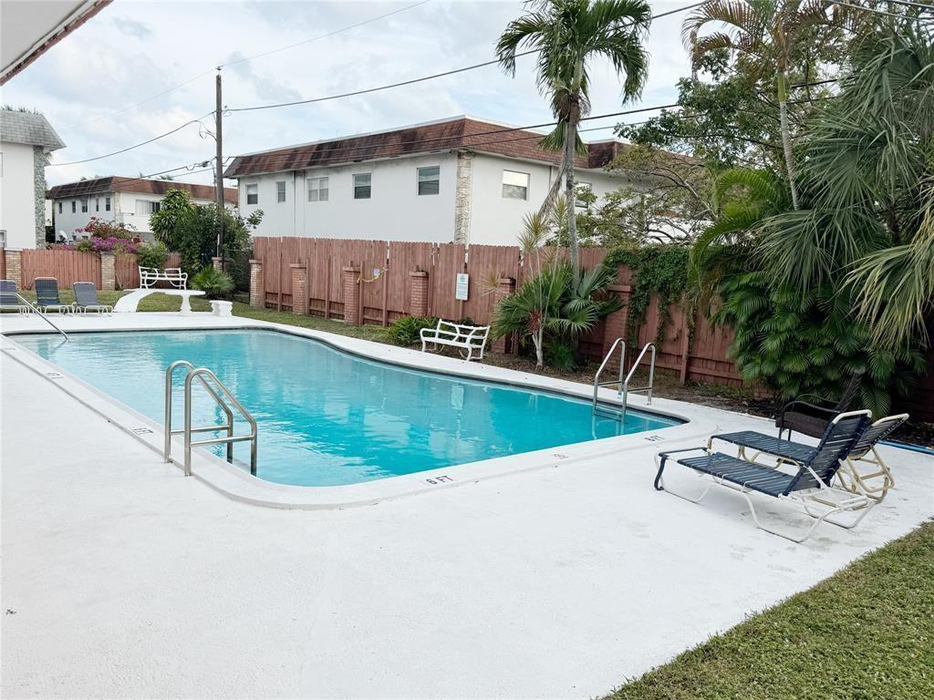 A rectangular swimming pool with a diving board is surrounded by a white concrete deck — 230 SW 1st Street # 8, Pompano Beach FL 33060, POMPANO BEACH, FL