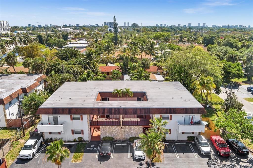 An aerial view of a two-story apartment building with a central courtyard and parking lot — 230 SW 1st Street # 8, Pompano Beach FL 33060, POMPANO BEACH, FL