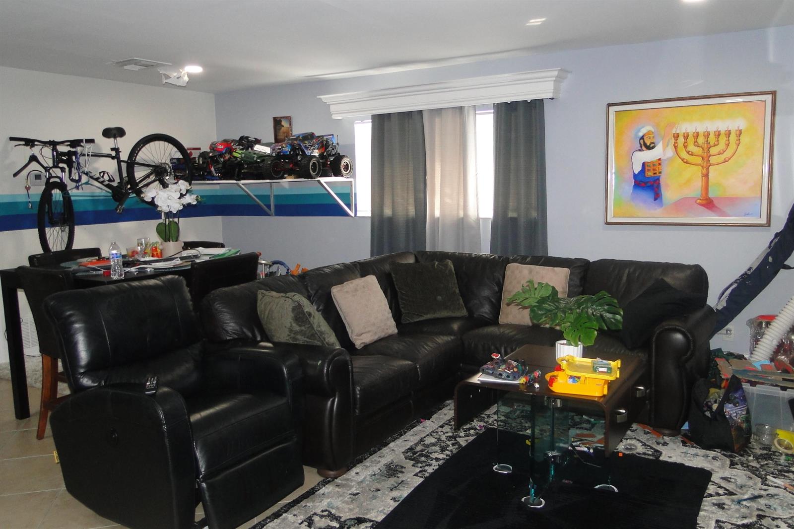 A living room features a black leather sectional, a recliner, a dining area, and wall art — 1829 N A Street # 14, FL 33460, FL