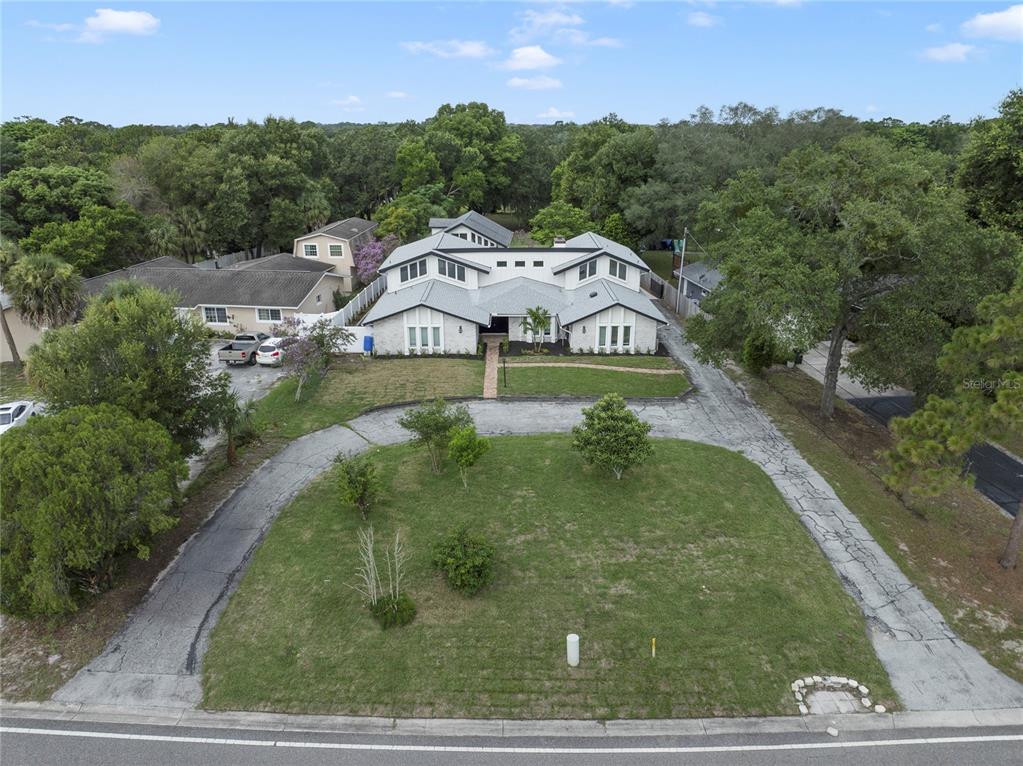 An aerial view shows a white two-story house with a large front lawn and driveway — 1048 CRYSTAL BOWL CIRCLE, CASSELBERRY, FL
