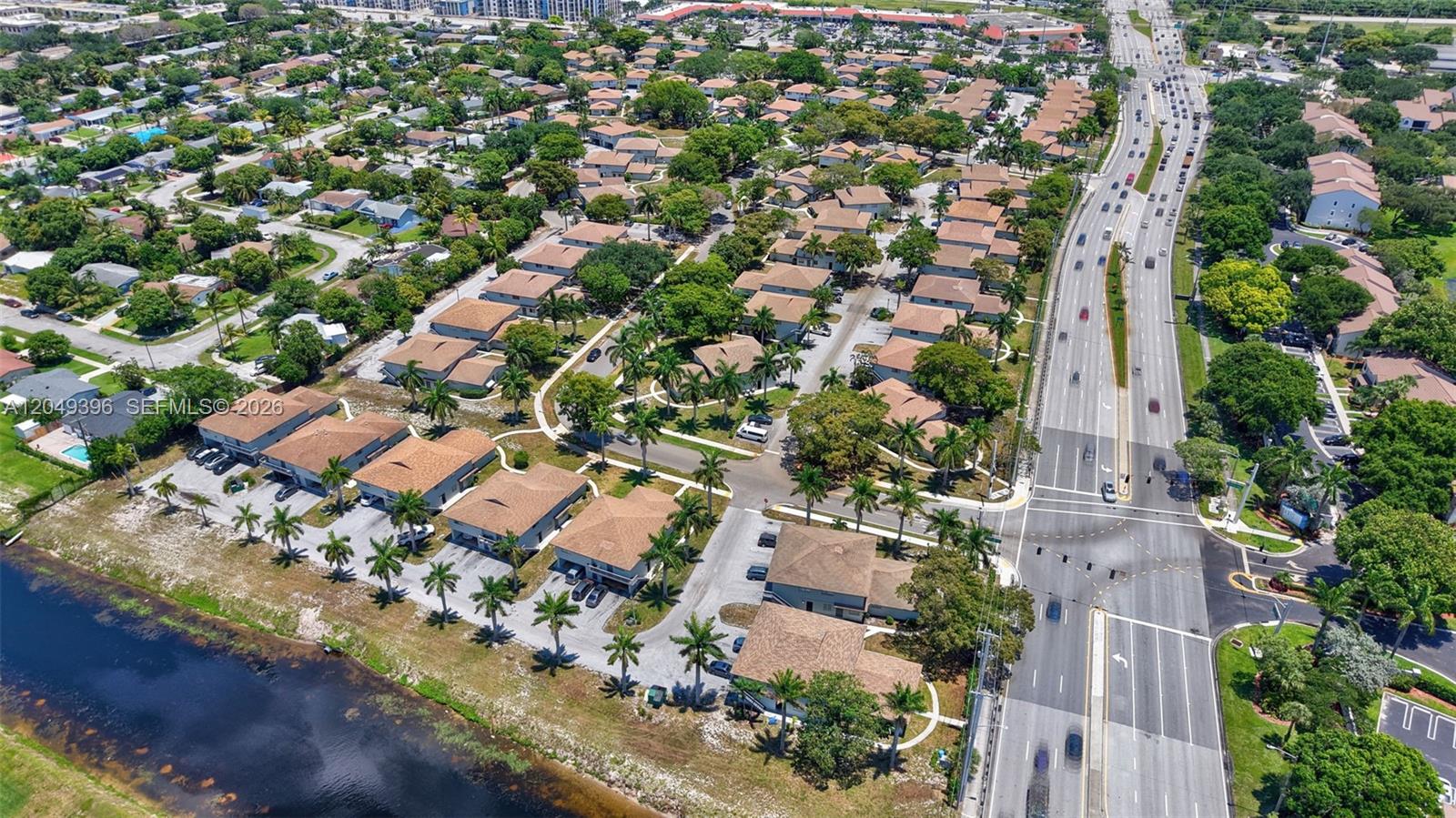 An aerial view shows a residential neighborhood with townhomes, palm trees, and a nearby highway — 1530 S Congress Ave # 2, Delray Beach FL 33445, DELRAY BEACH, FL