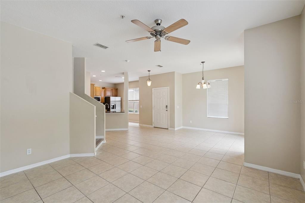 An open-concept living and dining area features tile flooring, a ceiling fan, and a kitchen — 15316 OAK APPLE COURT UNIT B, WINTER GARDEN, FL