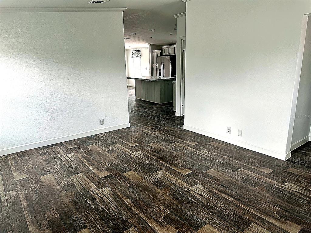 A view from a living area looking toward a kitchen with a central island — 3496 GREENBLUFF ROAD UNIT 1118, ZELLWOOD, FL