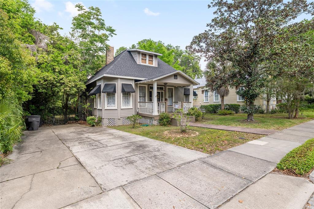 A gray one-story bungalow with a front porch and a concrete driveway — 721 SE 5TH STREET, OCALA, FL