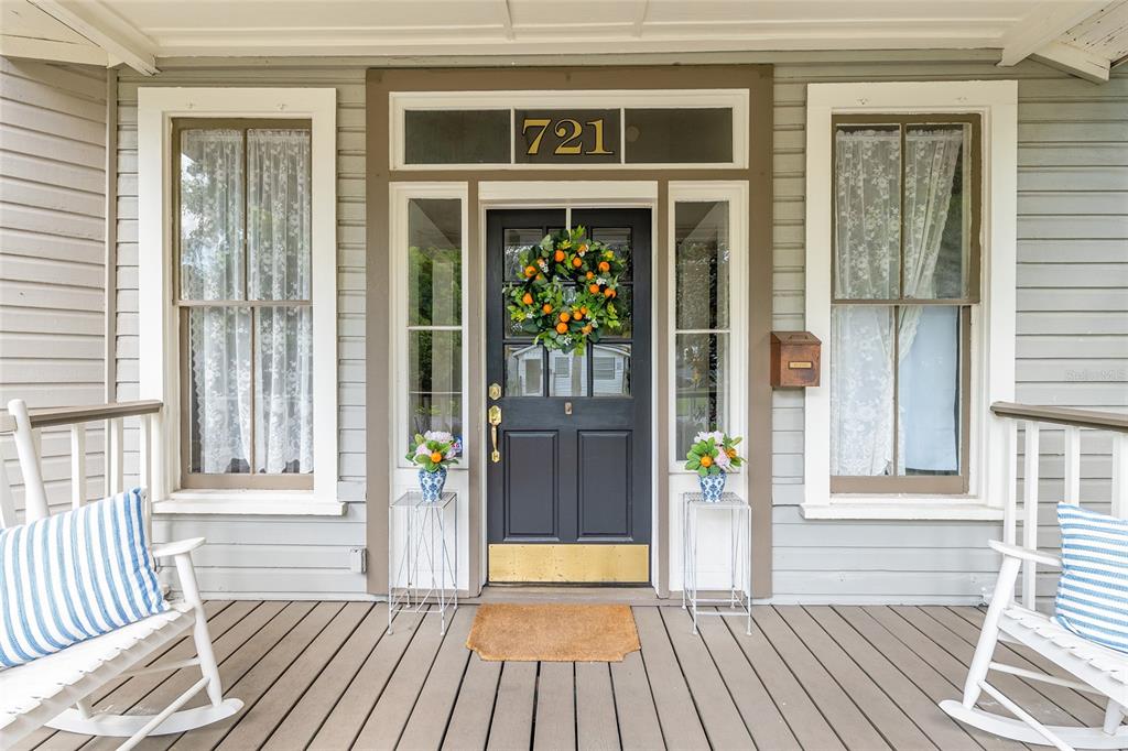 A front porch features a black door with a wreath, two rocking chairs, and windows — 721 SE 5TH STREET, OCALA, FL