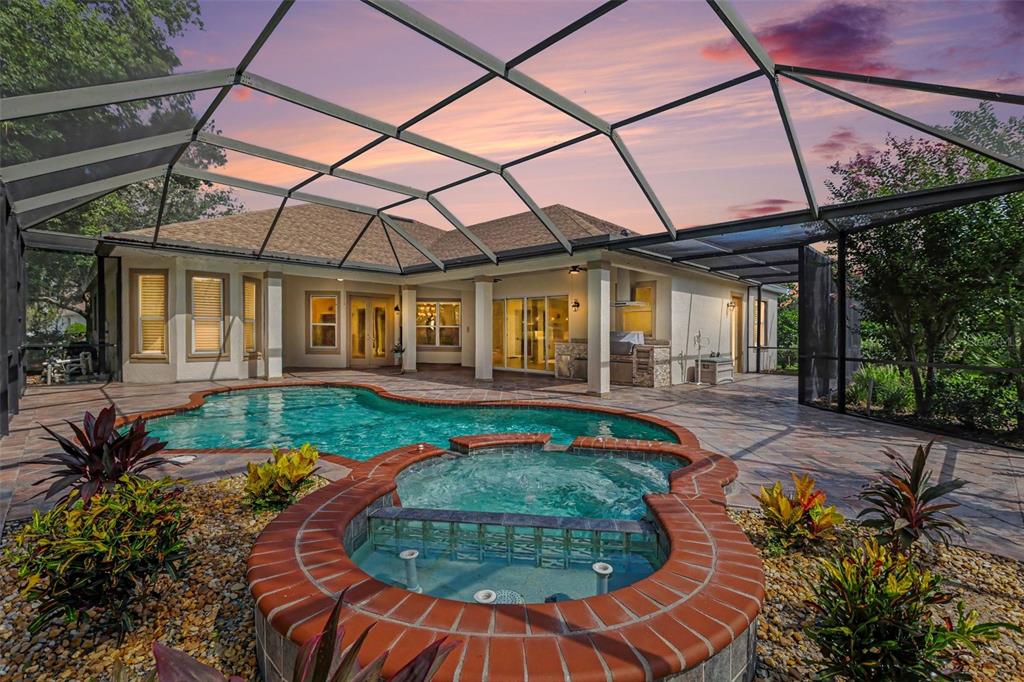 A screened-in patio features a swimming pool, a raised spa, and a covered outdoor kitchen — 2912 HAMPTON PLACE COURT, PLANT CITY, FL