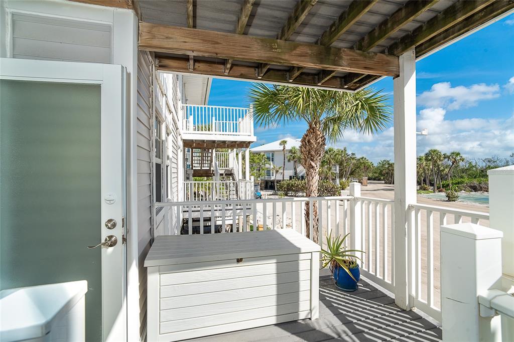 A wooden deck features a white storage chest, a potted plant, and a palm tree — 7466 PALM ISLAND DRIVE UNIT 2913, PLACIDA, FL