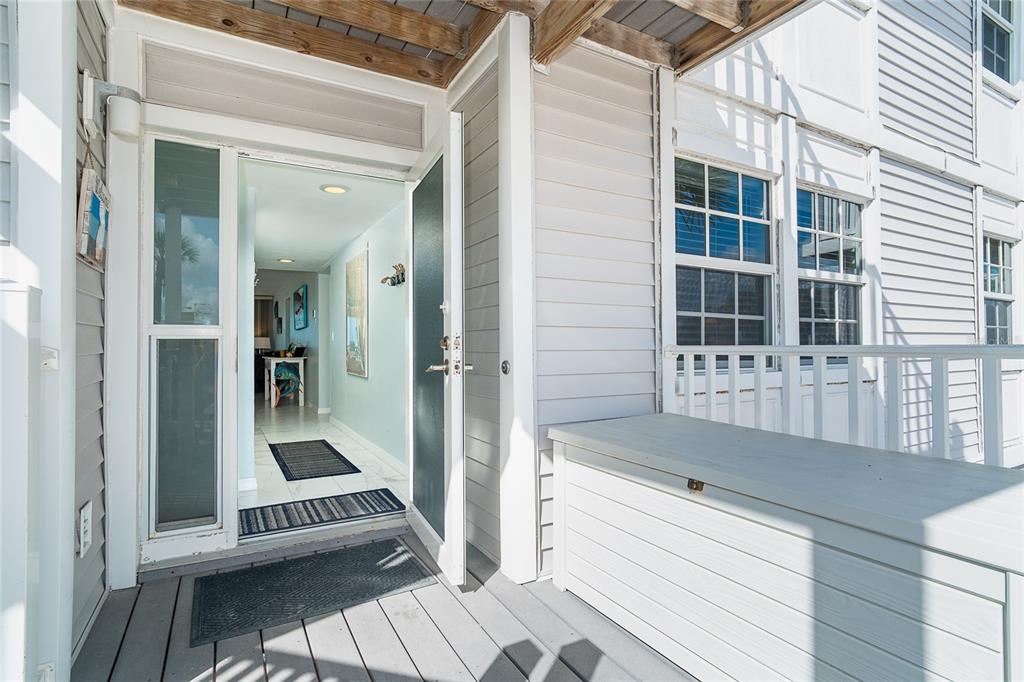 An open front door reveals a bright entryway with tile flooring and light blue walls — 7466 PALM ISLAND DRIVE UNIT 2913, PLACIDA, FL