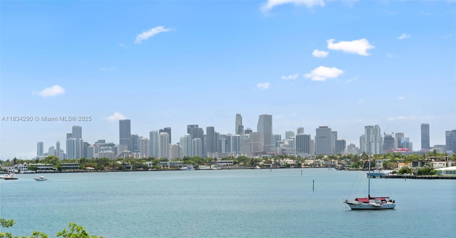 A view of the Miami skyline across a body of water with a sailboat — 9 Island Ave # 406, Miami Beach FL 33139, MIAMI BEACH, FL