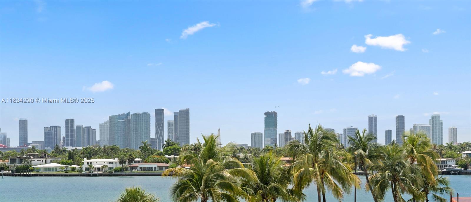 A view of the Miami skyline across a body of water with palm trees — 9 Island Ave # 406, Miami Beach FL 33139, MIAMI BEACH, FL