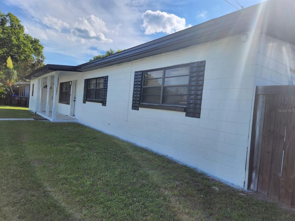 A white concrete block house with dark window shutters and a covered front porch — 8320 DOT LANE, ORLANDO, FL