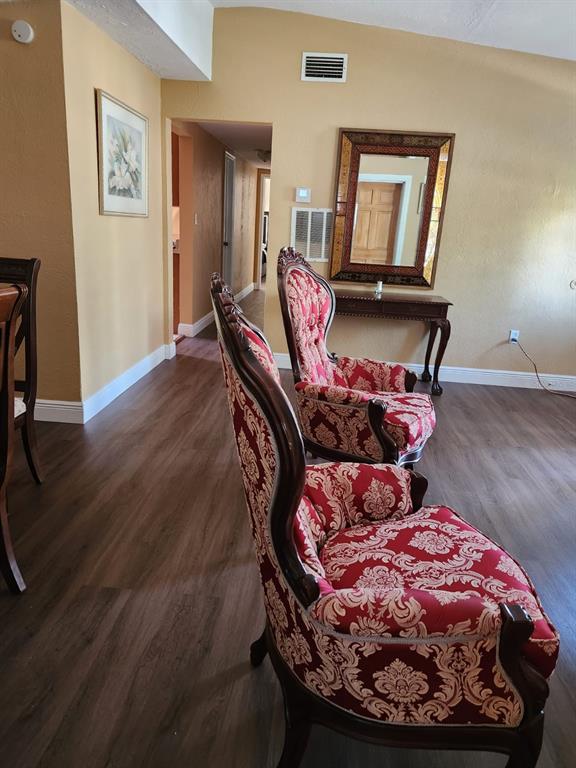 Two ornate red patterned armchairs sit on wood-look flooring in a room with yellow walls — 8320 DOT LANE, ORLANDO, FL