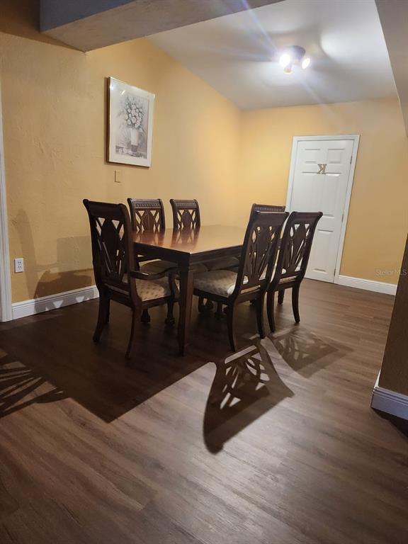 A dining room features a wooden table with six chairs on wood-look flooring — 8320 DOT LANE, ORLANDO, FL