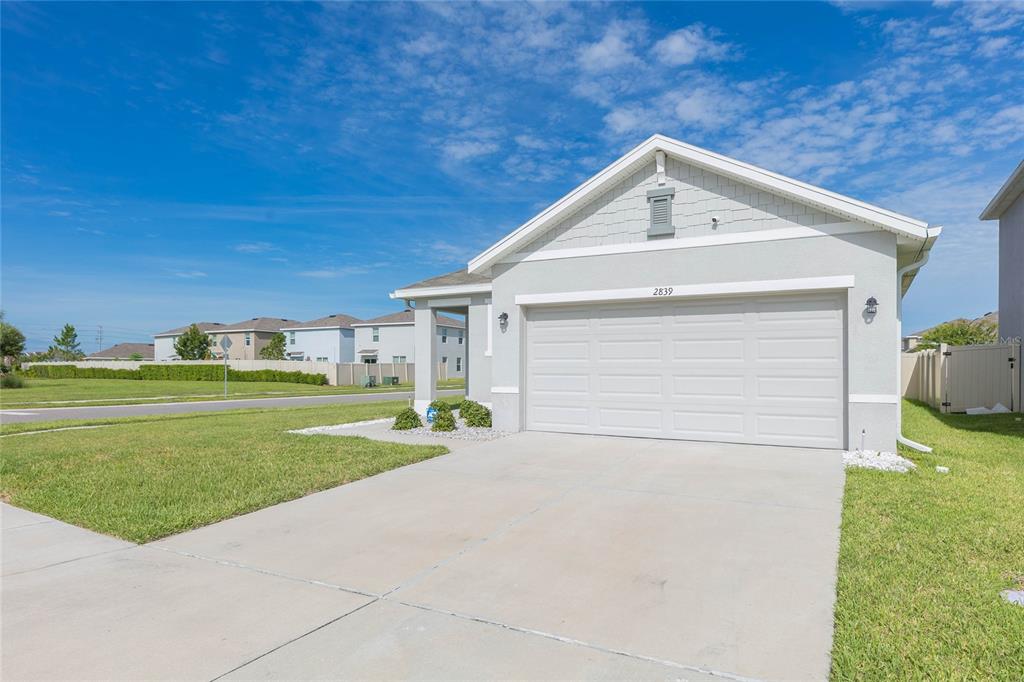 A single-story house with a light gray exterior and a two-car garage — 2839 MAIDEN GRASS ISLE, WESLEY CHAPEL, FL