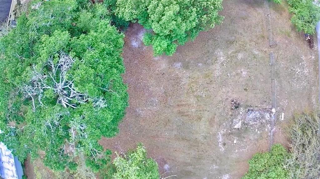 An aerial view shows a large, grassy lot bordered by mature trees and a fence — 139 N HOLLIS STREET, LAKE MARY, FL