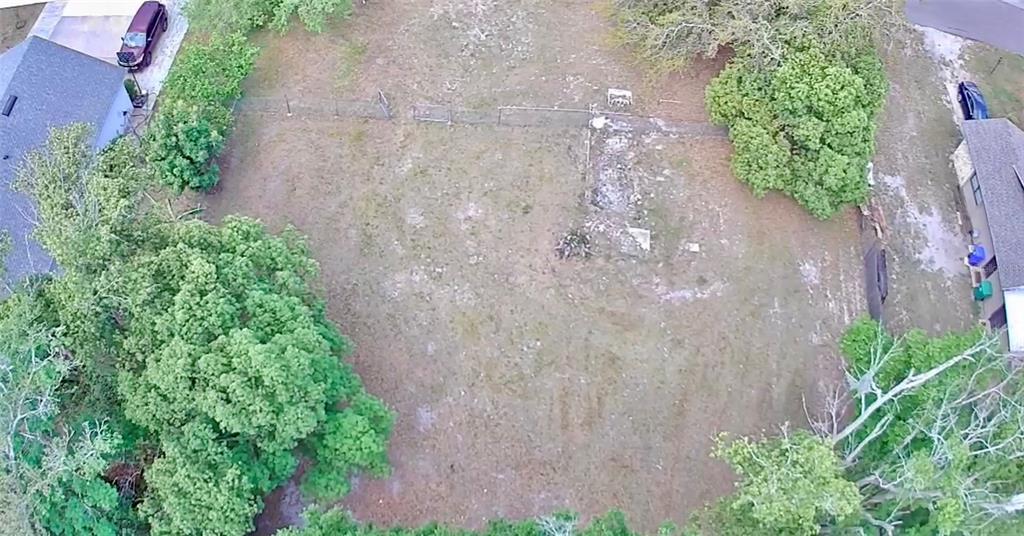 An aerial view shows a large, grassy residential lot with trees and a chain-link fence — 139 N HOLLIS STREET, LAKE MARY, FL
