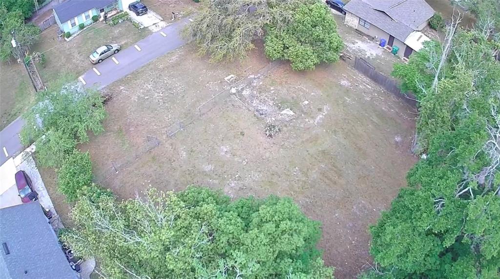 An aerial view shows a vacant, grassy residential lot surrounded by trees and neighboring houses — 139 N HOLLIS STREET, LAKE MARY, FL