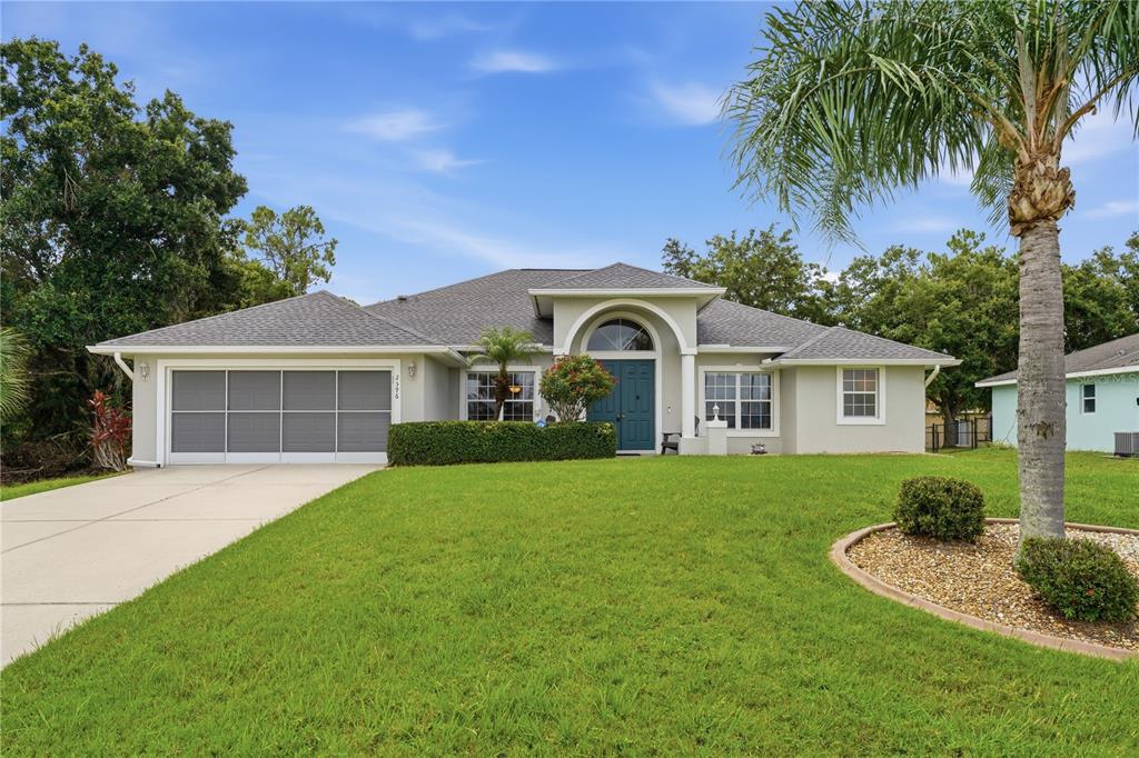 A single-story house with a gray roof, light-colored stucco exterior, and a two-car garage — 2596 SHALIMAR TERRACE, NORTH PORT, FL