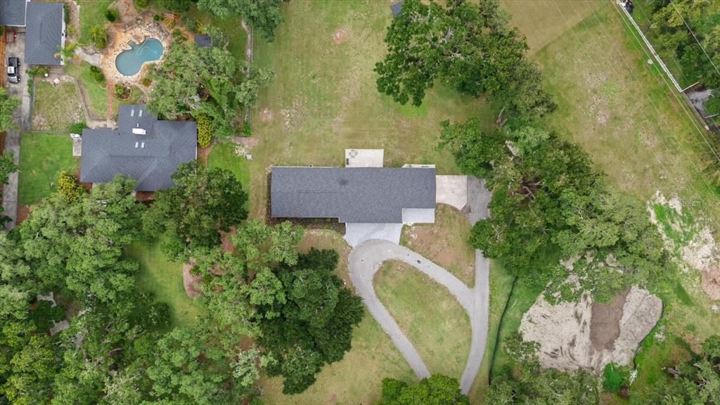 An aerial view shows two houses on a wooded lot with a pool and driveway — 3518 BERGER ROAD, LUTZ, FL