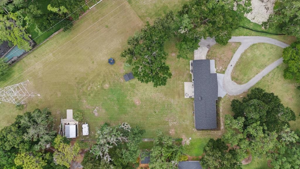 An aerial view shows a house with a dark roof, a driveway, and a large yard — 3518 BERGER ROAD, LUTZ, FL