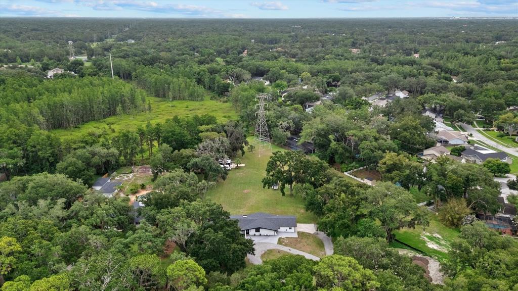 An aerial view shows a single-story house situated on a large lot with power lines — 3518 BERGER ROAD, LUTZ, FL