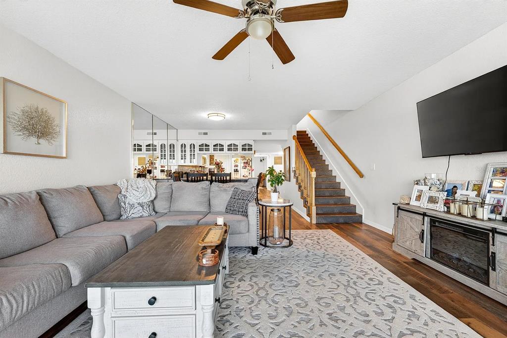 A living room features a grey sectional sofa, a wooden coffee table, and a staircase — 14793 SEMINOLE TRAIL, SEMINOLE, FL