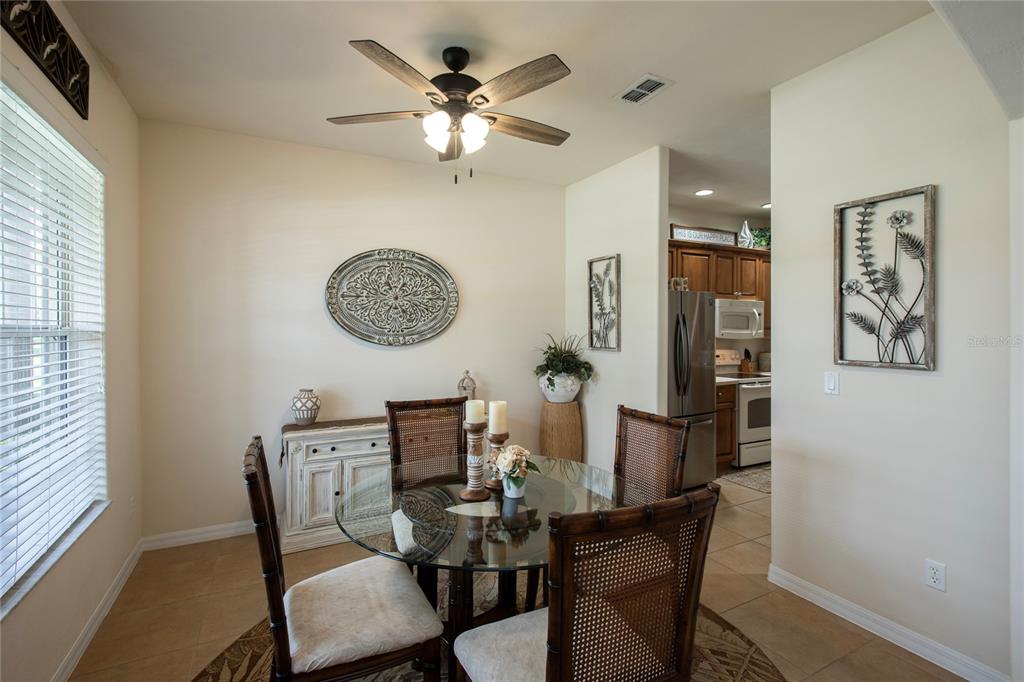A dining area features a glass-topped table, four rattan chairs, and a white sideboard — 3655 CASALTA CIRCLE, NEW SMYRNA BEACH, FL