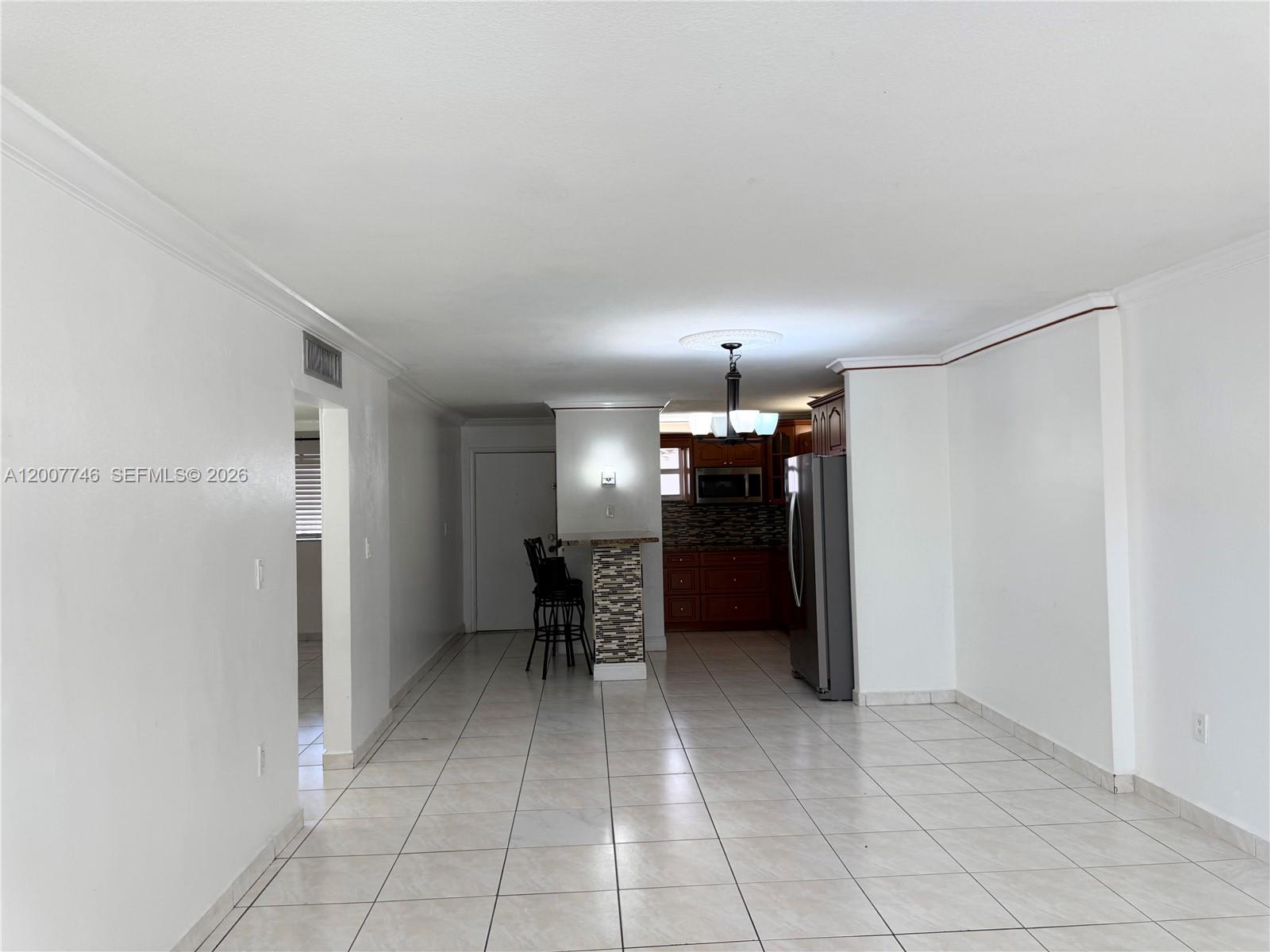 This room features white walls, tiled flooring, and an open kitchen with a breakfast bar — 1850 W 56th St # 2404, Hialeah FL 33012, HIALEAH, FL