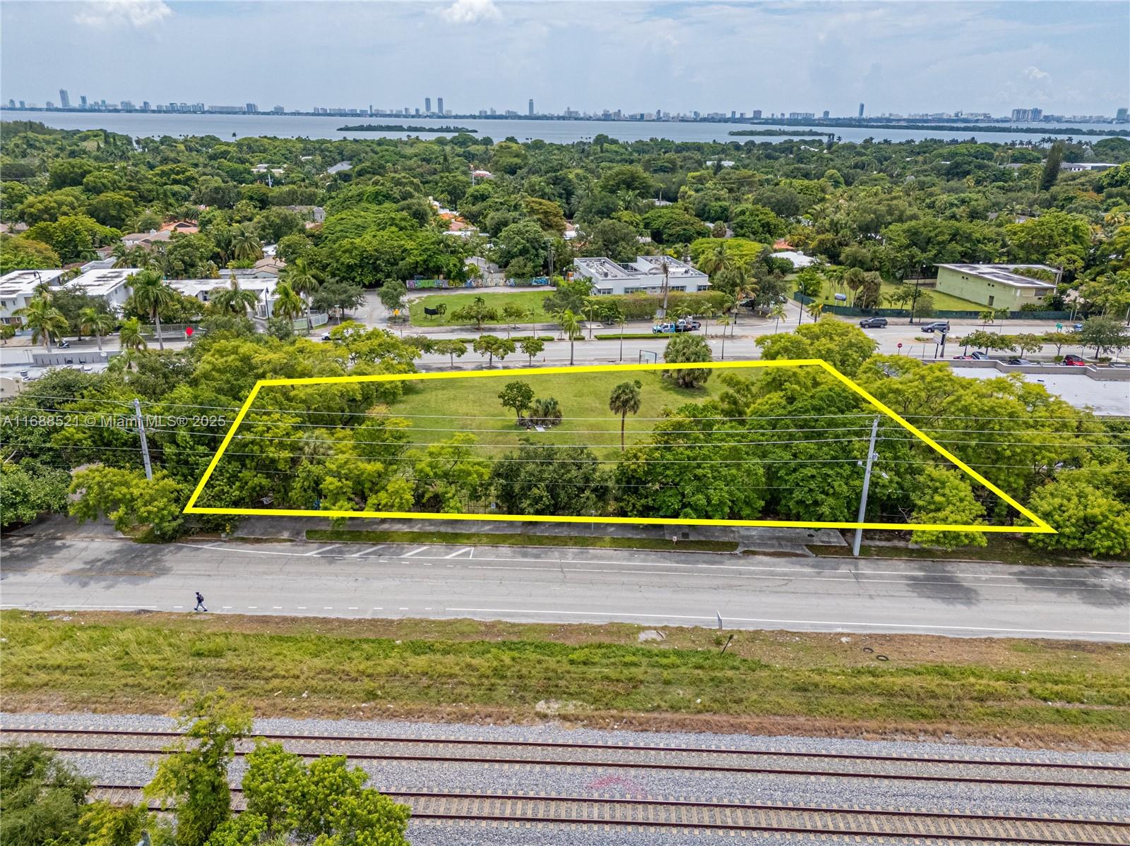 An aerial view shows a rectangular vacant lot outlined in yellow near a road and tracks — 5220 Biscayne, Miami FL 33137, MIAMI, FL