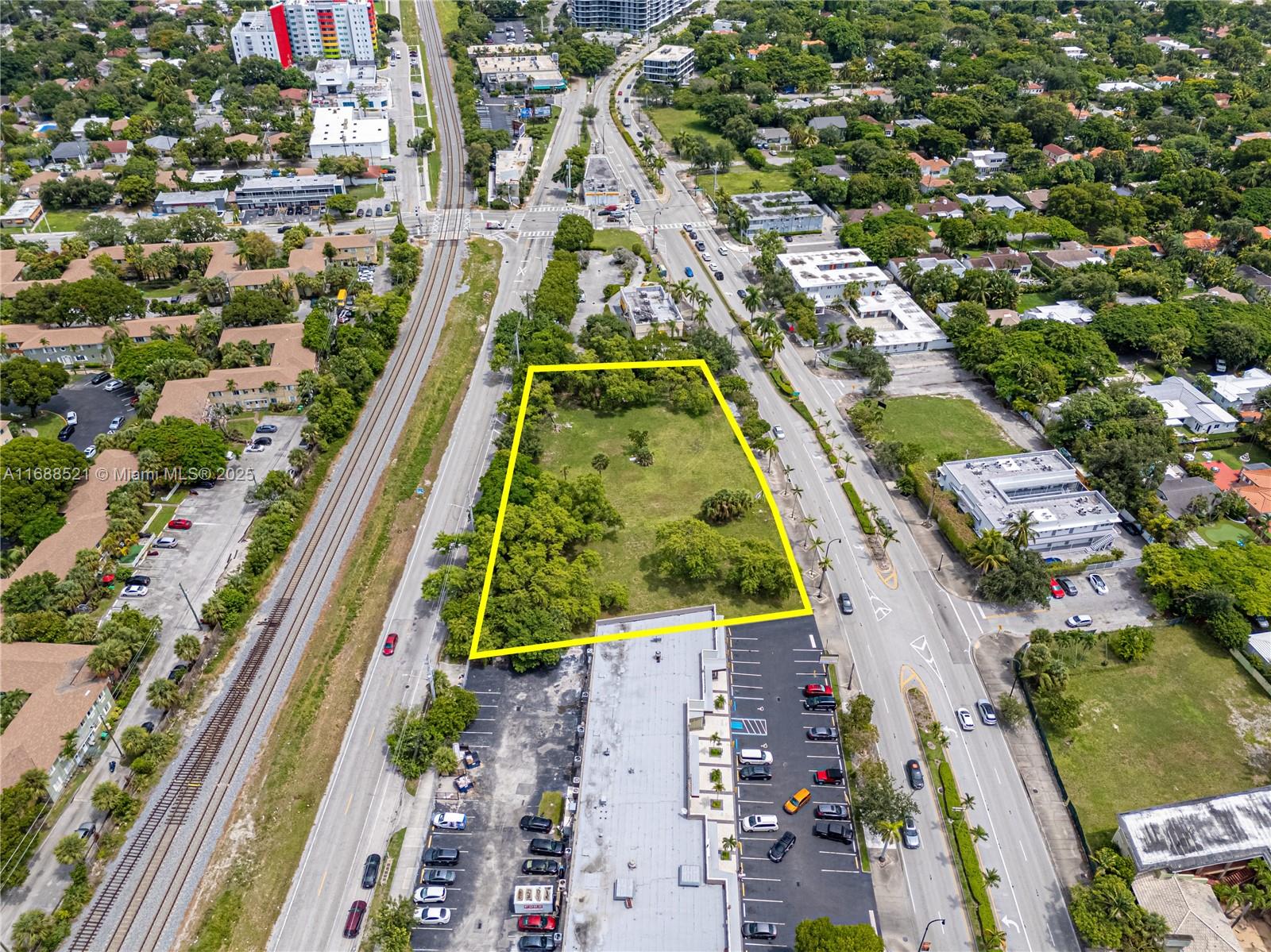 An aerial view shows a vacant, tree-filled rectangular lot outlined in yellow between two roads — 5220 Biscayne, Miami FL 33137, MIAMI, FL