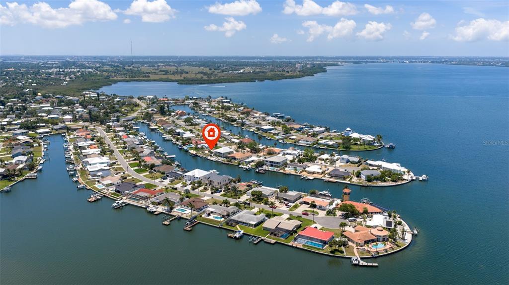 An aerial view shows a waterfront residential neighborhood with a house marked by a pin — 5108 COMMONWEALTH ROAD, PALMETTO, FL