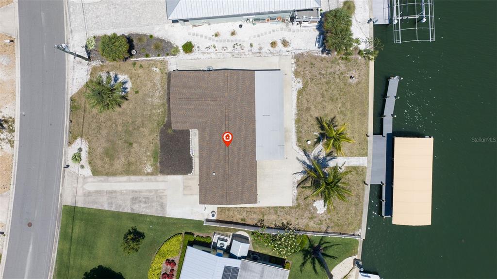 An aerial view shows a house with a brown roof, a boat dock, and waterfront access — 5108 COMMONWEALTH ROAD, PALMETTO, FL