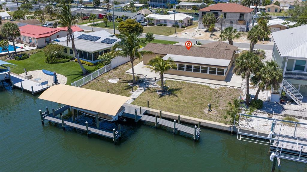 An aerial view of a waterfront house with a boat dock and lift — 5108 COMMONWEALTH ROAD, PALMETTO, FL