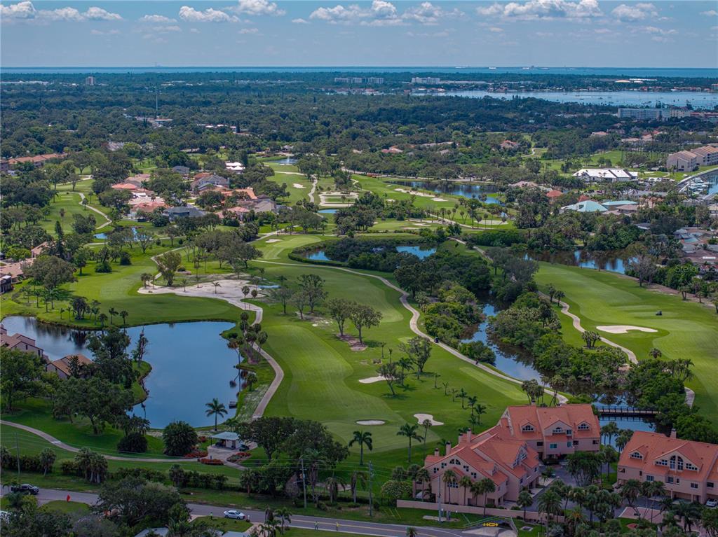 An aerial view of a golf course surrounded by residential buildings and water features — 6709 CARDINAL DRIVE S, ST PETERSBURG, FL