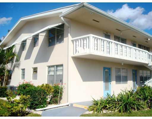 A two-story apartment building with a white exterior, a balcony, and blue doors — 183 Andover H, West Palm Beach FL 33417, WEST PALM BEACH, FL