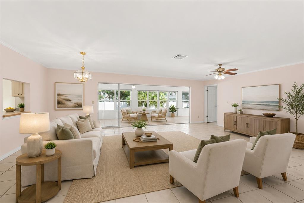 A living room with light walls, tile floors, a sofa, two armchairs, and sliding doors — 1703 NEW BEDFORD DRIVE, SUN CITY CENTER, FL