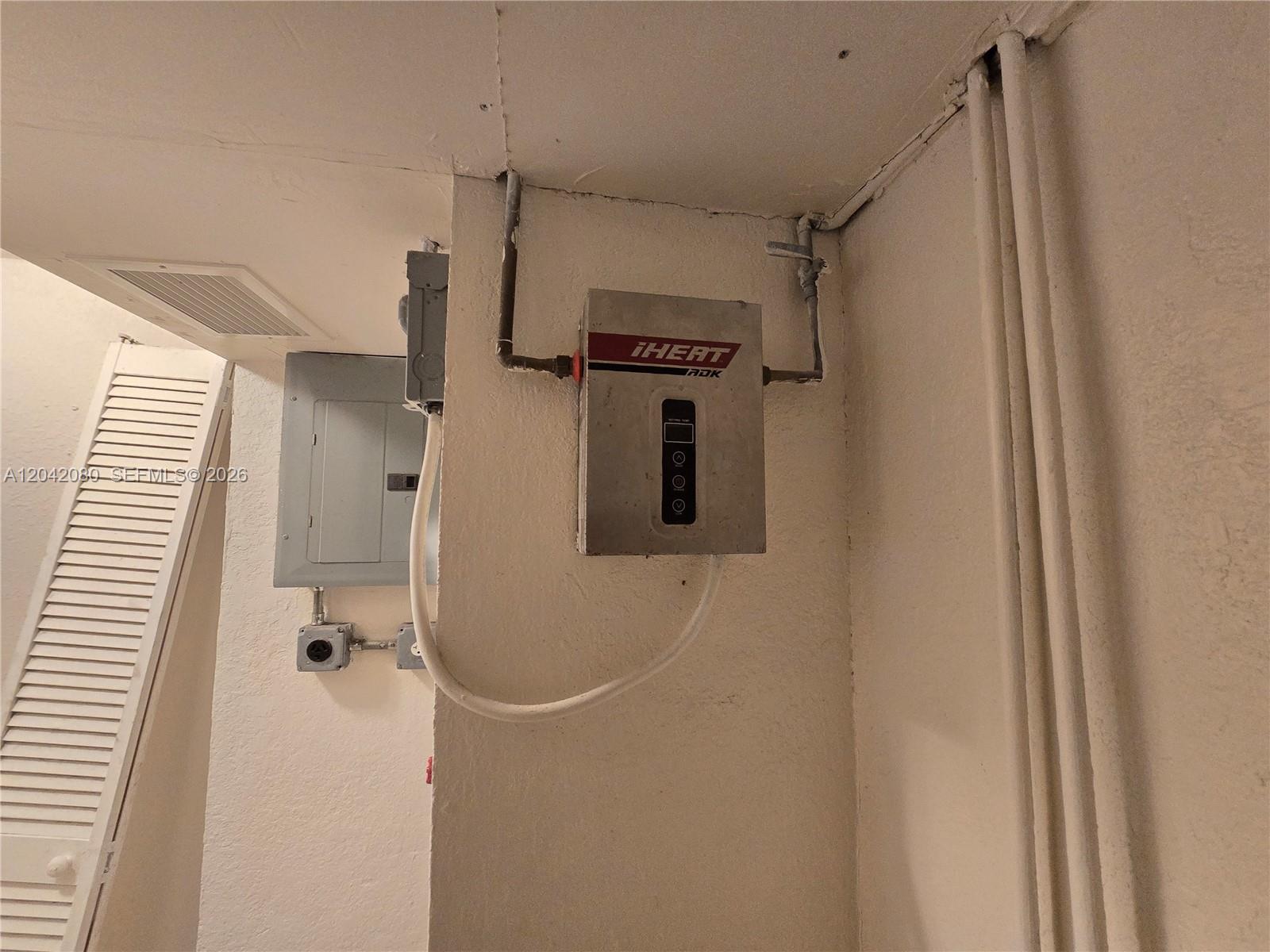 An electric tankless water heater is mounted on a wall next to an electrical panel — 2203 Taft St # B, Hollywood FL 33020, HOLLYWOOD, FL