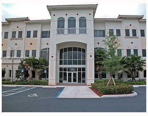 A three-story commercial building with a central glass entrance and a parking lot in front — 2893 Executive Park Dr, Weston FL 33331, WESTON, FL