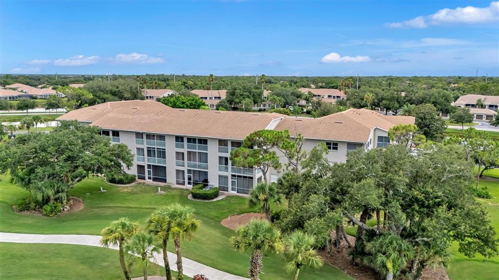 A living room features a sectional sofa, a ceiling fan, and sliding doors to a balcony — 9620 CLUB SOUTH CIRCLE UNIT 5107, SARASOTA, FL