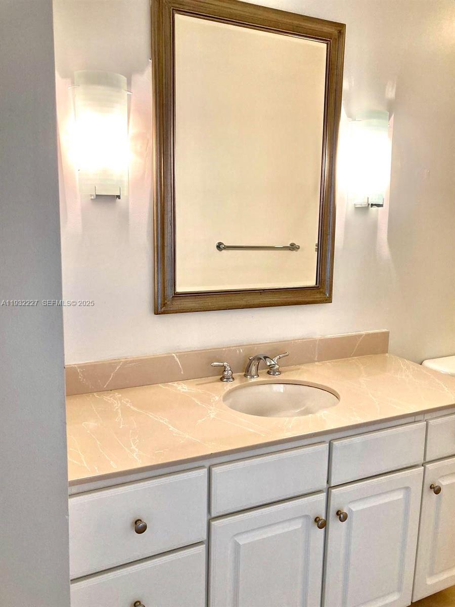 A bathroom features a white vanity with a light-colored countertop, sink, and a wall mirror — 2001 Biscayne Blvd # 2608, Miami FL 33137, MIAMI, FL