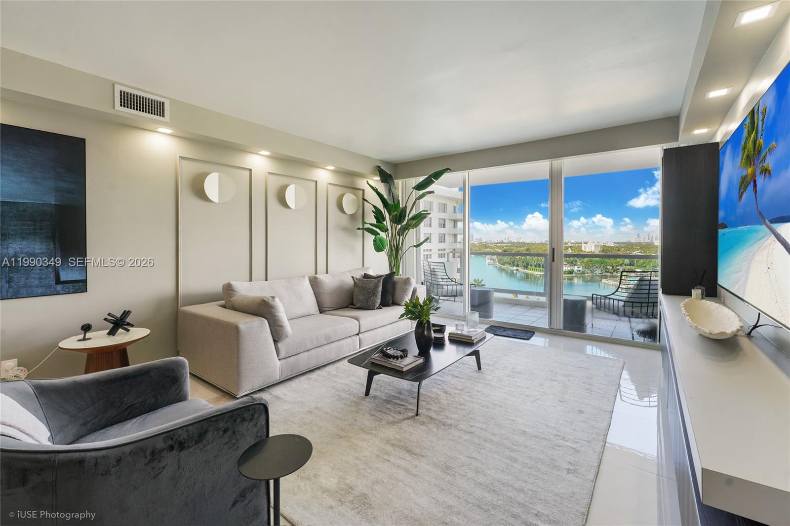 A modern living room features a beige sofa, a black coffee table, and a balcony view — 5161 Collins Ave # 1508, Miami Beach FL 33140, MIAMI BEACH, FL