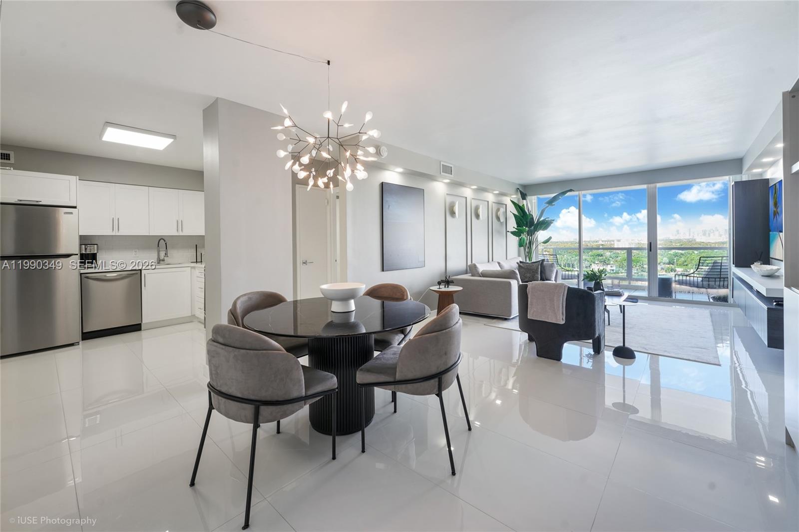 A modern open-concept living and dining area features white tile floors and a balcony view — 5161 Collins Ave # 1508, Miami Beach FL 33140, MIAMI BEACH, FL