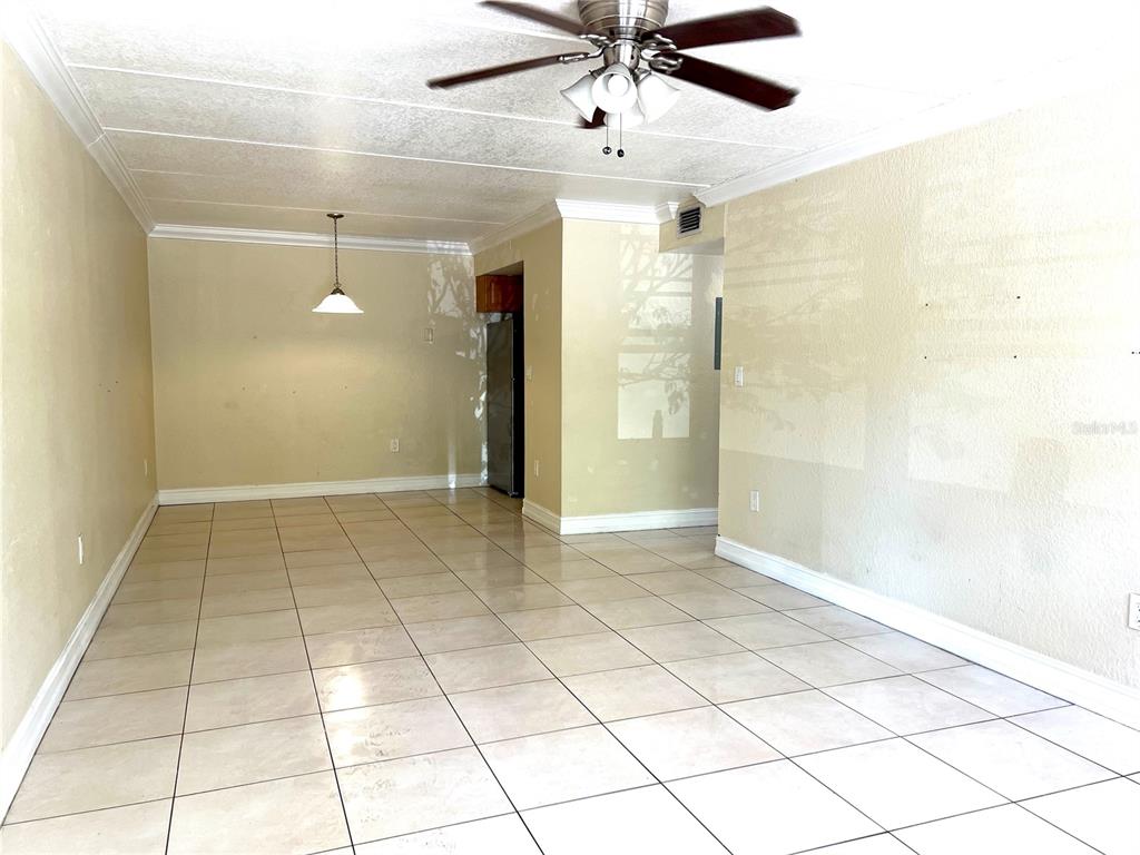 An empty room with light-colored tile flooring, a ceiling fan, and a pendant light fixture — 5221 BAYSHORE BOULEVARD UNIT 29, TAMPA, FL