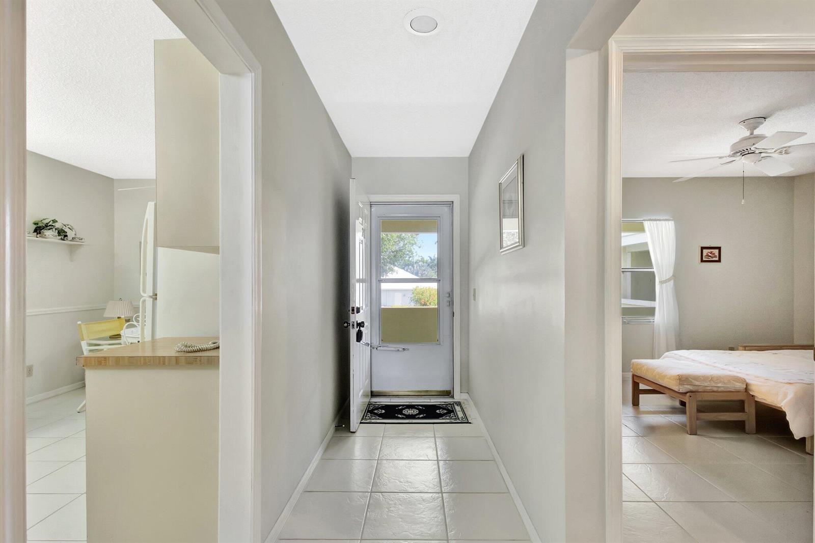 A tiled entryway leads to a front door, flanked by a kitchen and a bedroom — 1600 SE Saint Lucie Boulevard SE # 211, Stuart FL 34996, STUART, FL