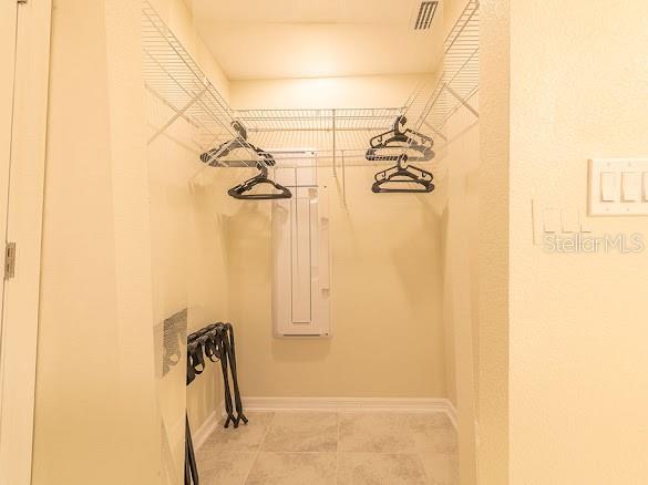 A walk-in closet with wire shelving, hanging clothes hangers, and a light-colored tiled floor — 3120 PARADOX CIRCLE UNIT 108, KISSIMMEE, FL