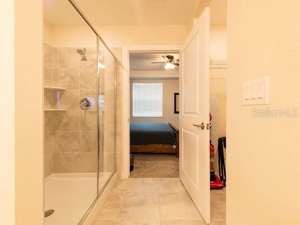 A bathroom with a glass-enclosed shower and a doorway leading into a bedroom — 3120 PARADOX CIRCLE UNIT 108, KISSIMMEE, FL
