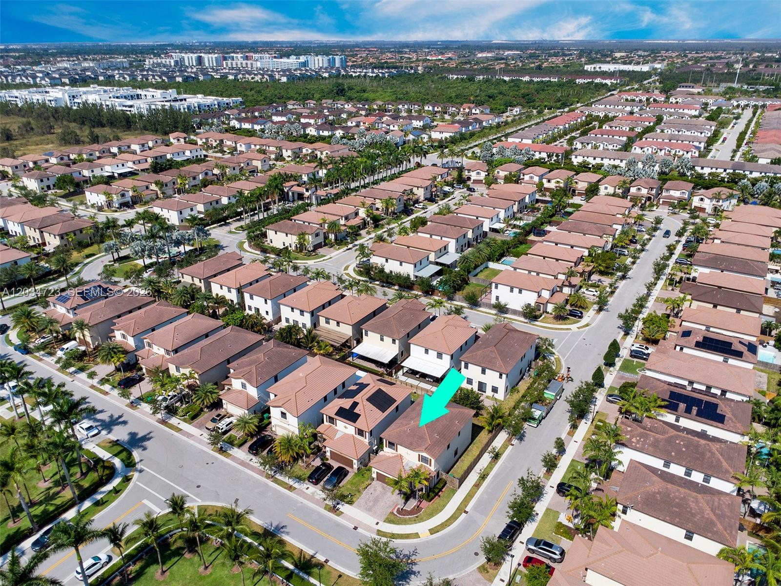 An aerial view shows a suburban neighborhood with a teal arrow pointing to a house — 8890 NW 99th Path, Doral FL 33178, DORAL, FL