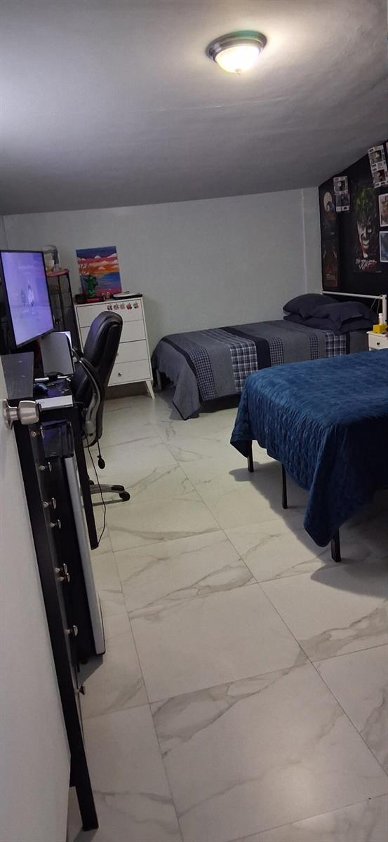 A bedroom features two beds, a computer desk, white tile flooring, and a dark accent wall — 1519 S 24th Terrace, Hollywood FL 33020, HOLLYWOOD, FL