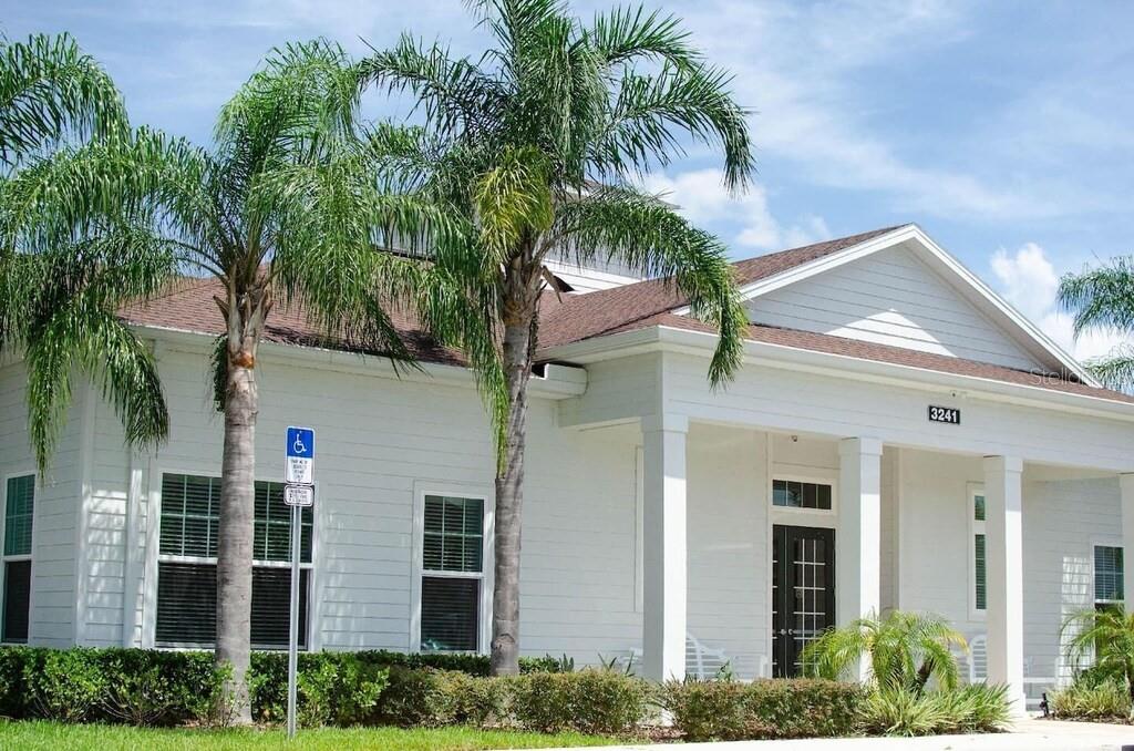 A white building with a covered porch, palm trees, and a handicap parking sign — 8905 SHINE DRIVE, KISSIMMEE, FL